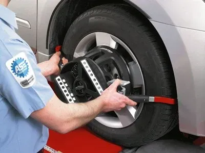 A man checking the car tyre alignment
